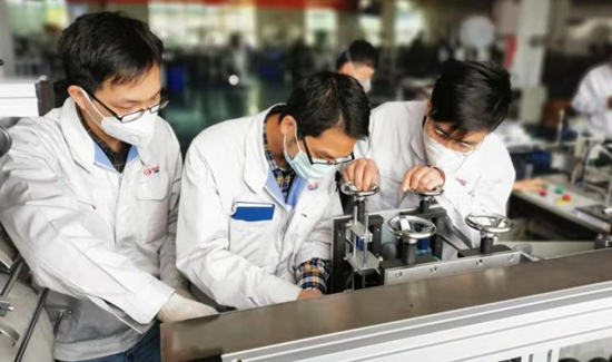 图2-(来源于媒体报道)广汽部件工程师在研究口罩设备相关技术和生产流程.jpg